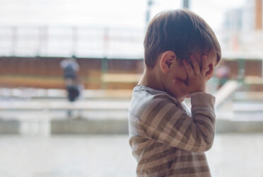 enfant 2 ans, en surcharge emotionnelle, qui se cache les yeux