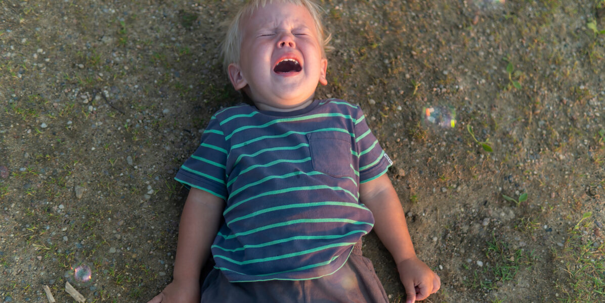Un garçon part terre frustré, en pleine crise de pleurs