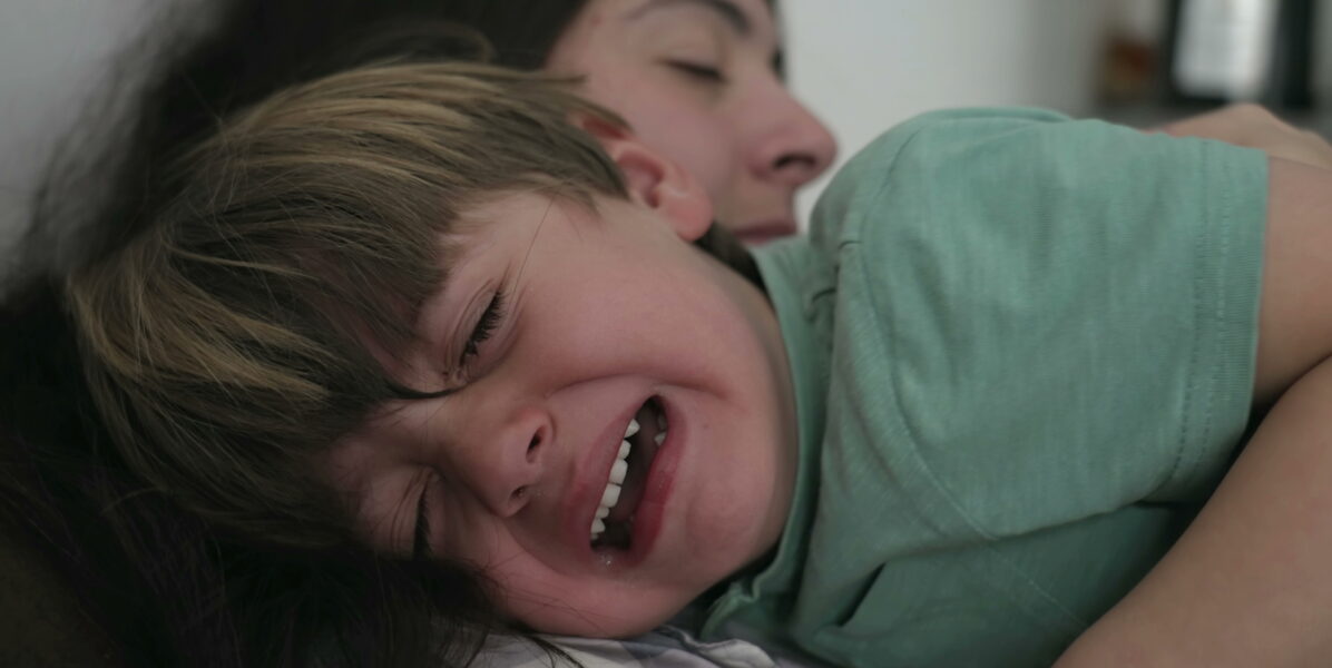 Enfant en crise de terreur nocturne dans les bras de sa maman