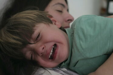 Enfant en crise de terreur nocturne dans les bras de sa maman