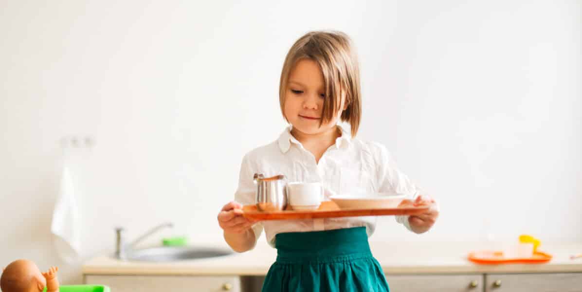 Enfant de 3 ans qui installe un plateau de vie pratique Montessori