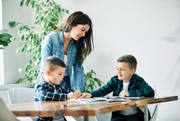 Des enfants entre 3 et 6 ans qui sont concentrés et écoutent leur maman